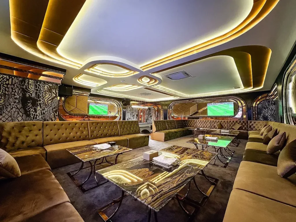 VIP karaoke room with brown sofas, TV screen, marble tables, and a modern design