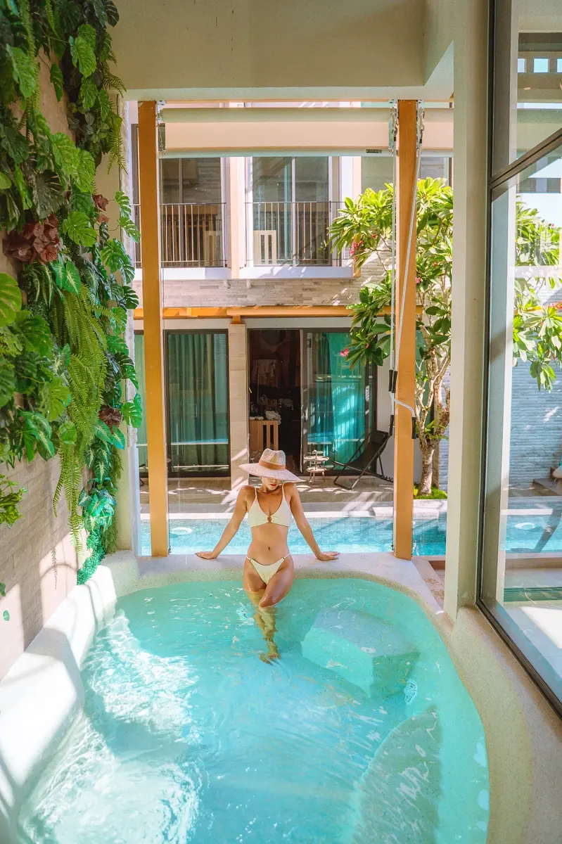 Hot woman posing on a jacuzzi with the view of the swimming pool behind