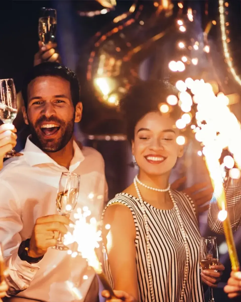 People celebrating with glasses of champagne and sparklers